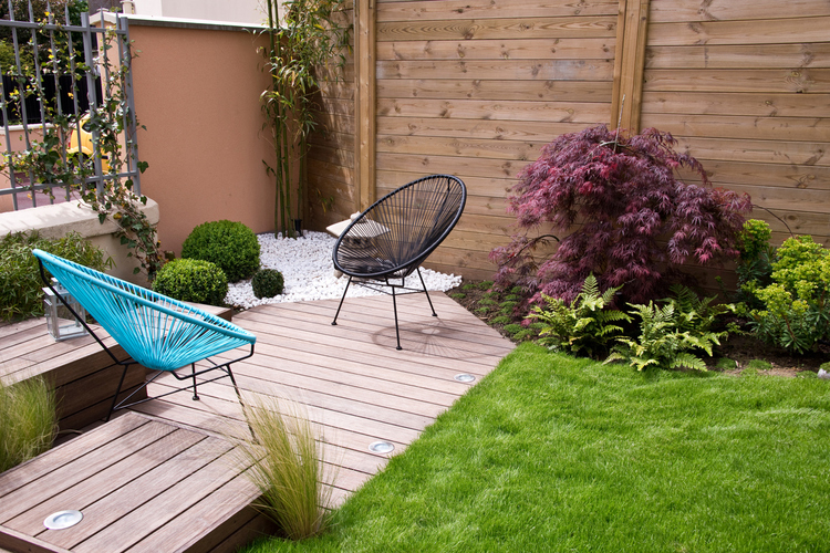 Moderan minimalistički vrt sa zelenim površinama i udobnim stolicama